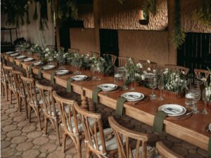 Mesas de madera con sillas crossback montadas en La Pesebrera