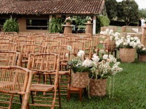 Sillas de ceremonia con arreglos florales frente a la casa de la hacienda
